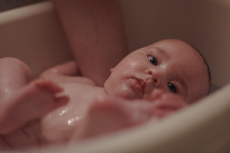 Portrait d'un bébé lors de son bain, prise pendant une séance photo à domicile à Venoy dans l'yonne.