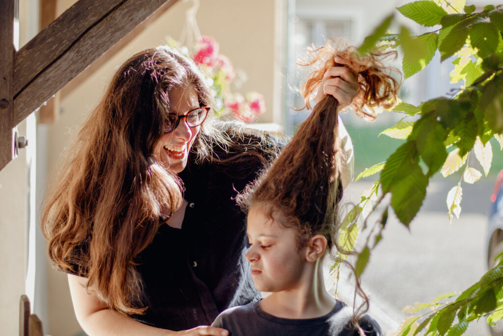 Maman et sa fille partageant un moment complice au soleil, dans un champ près d’Auxerre, en Bourgogne.