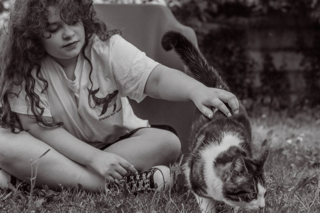 petite fille et son chat jouent dans le jardin. photographie noire et blanche à Auxerre.