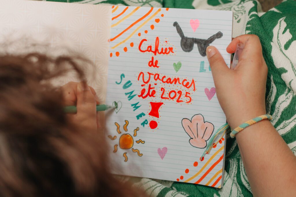 Couverture personnalisée d’un carnet de vacances décorée par un enfant avec des dessins et stickers colorés