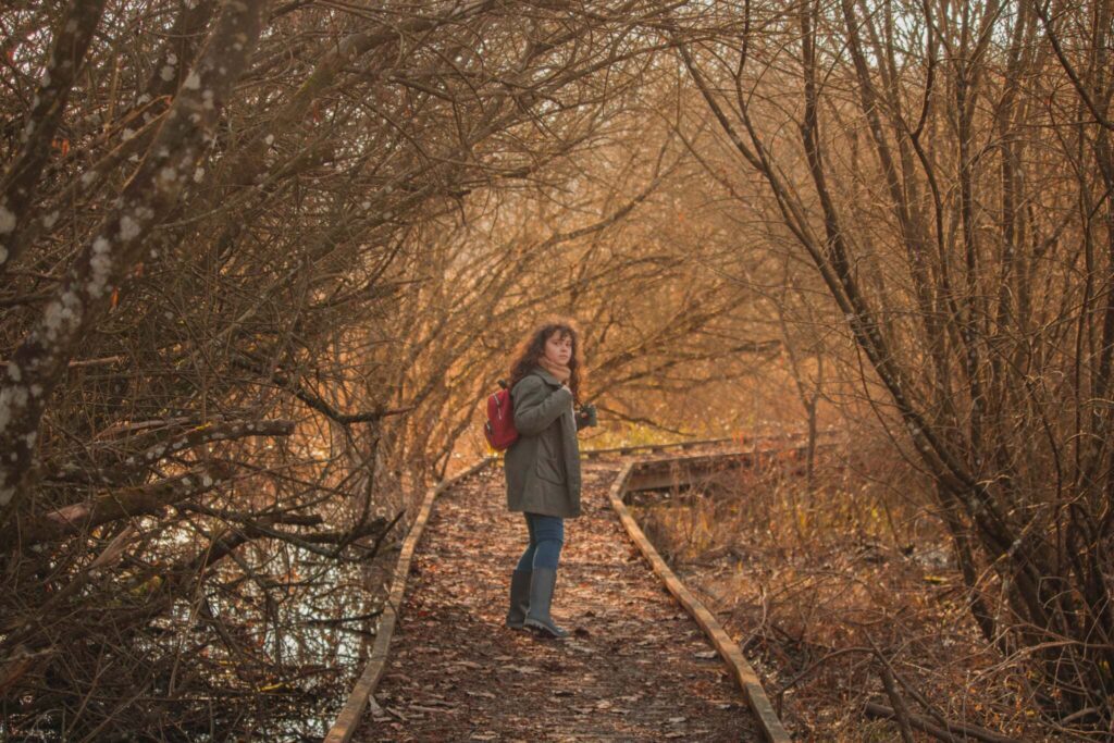 Petite fille sur la même passerelle au marais d'Andryes, photo professionnelle avec composition soignée, lumière maîtrisée et style cinématographique.