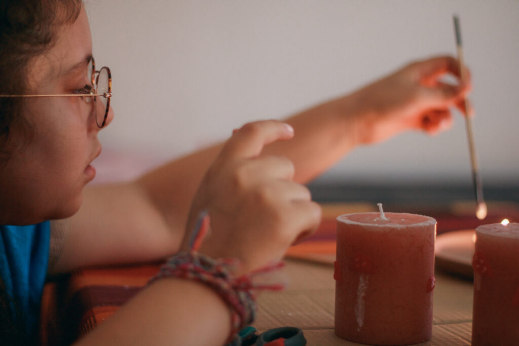 Activité automne cosy : une enfant décore des bougies maison en DIY avec sa maman
