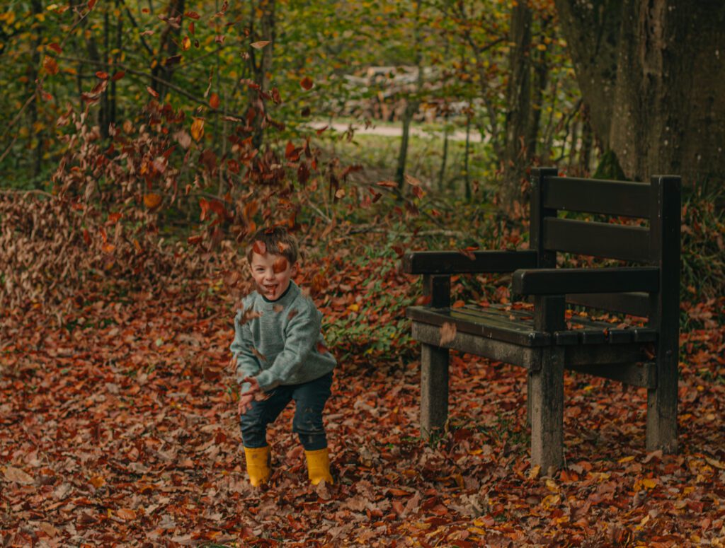 Famille avec enfants jouant dans les feuilles mortes lors d'une séance photo d'automne dans l’Yonne