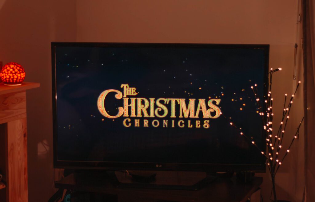 Ambiance cosy de Noël avec un écran où apparaît le film Les chroniques de Noel