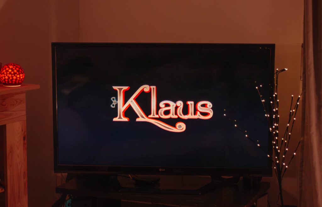 Ambiance cosy de Noël avec un écran où apparaît le film Klaus