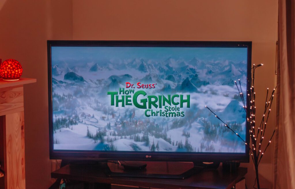 Ambiance cosy de Noël avec un écran où apparaît le film Le Grinch