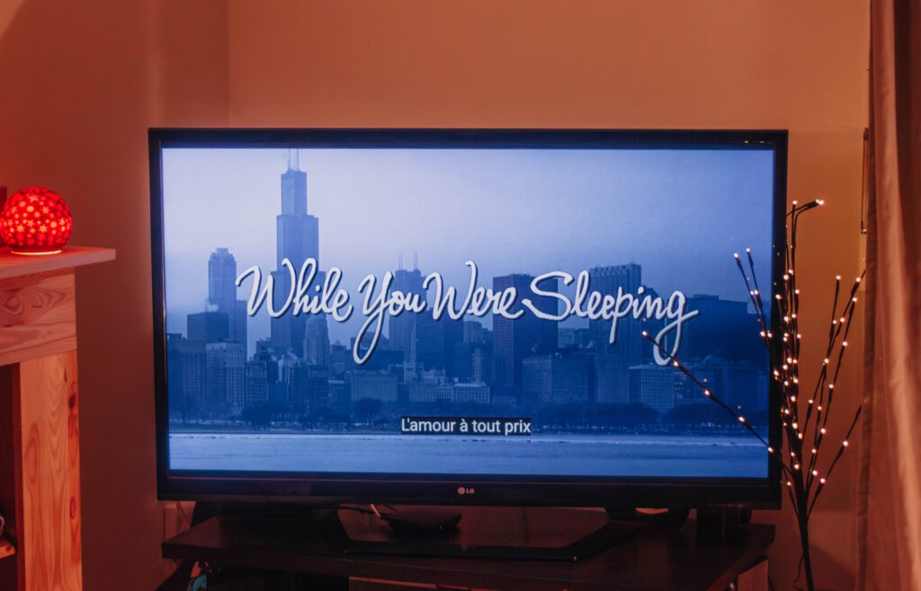 Ambiance cosy de Noël avec un écran où apparaît le film L'amour à tout prix