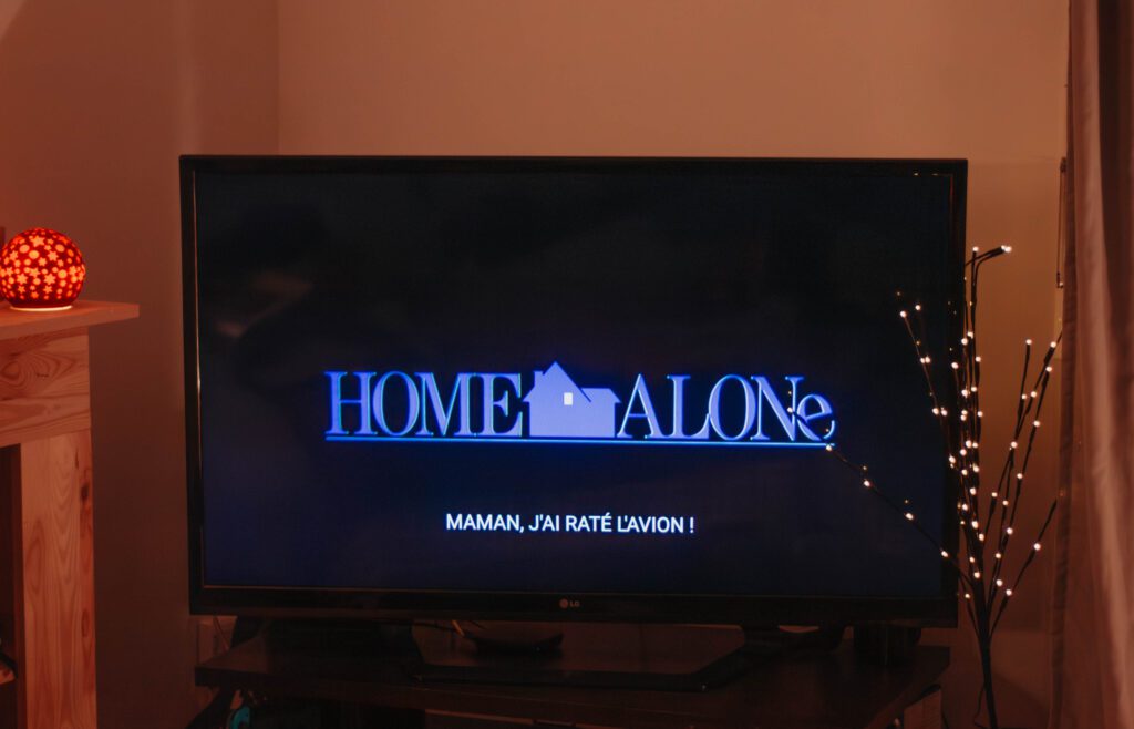 Ambiance cosy de Noël avec un écran où apparaît le film Maman, j'ai raté l'avion.