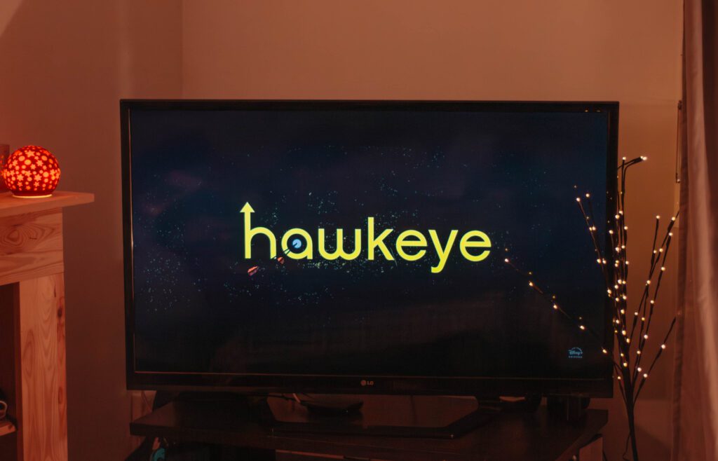 Ambiance cosy de Noël avec un écran où apparaît la série Hawkeye.