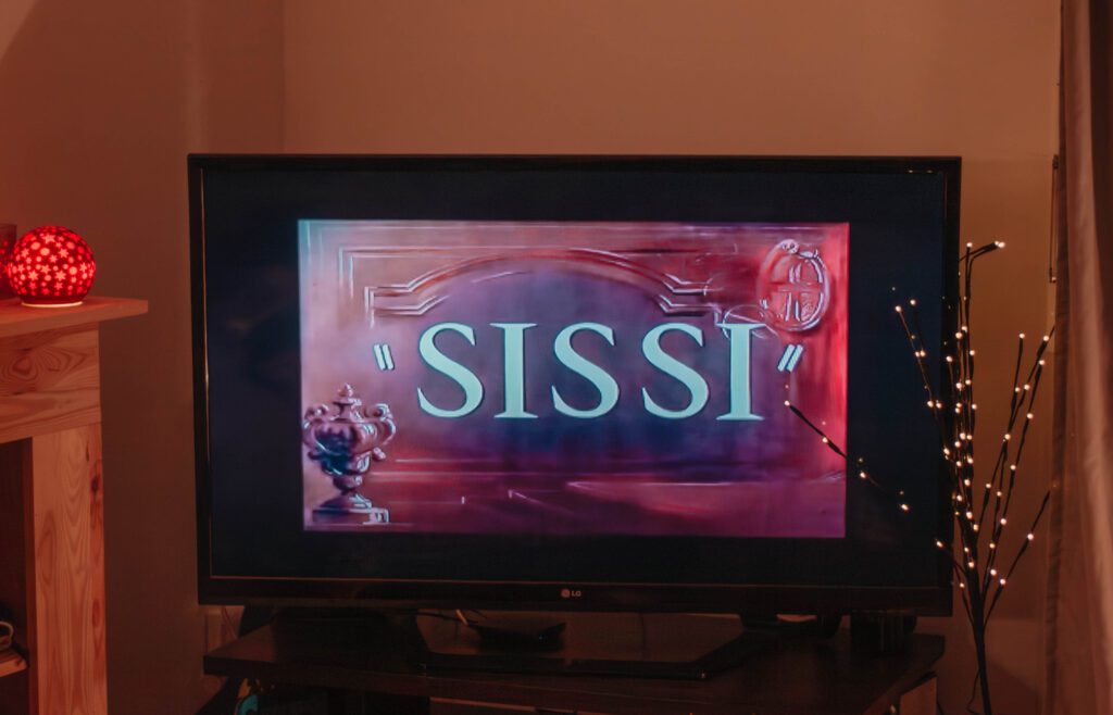 Ambiance cosy de Noël avec un écran où apparaît le film Sissi