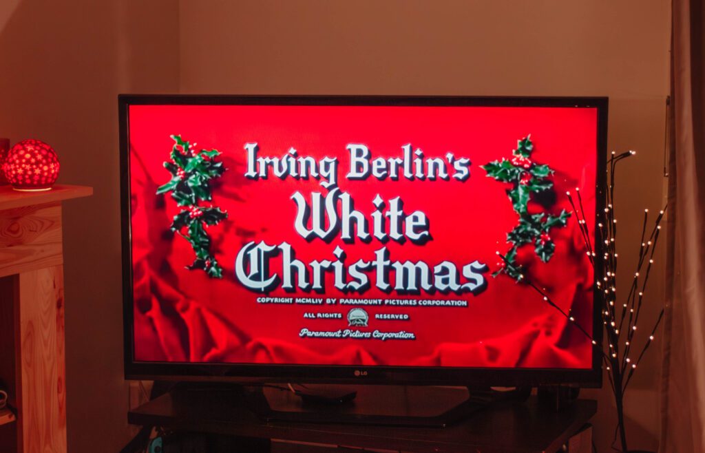Ambiance cosy de Noël avec un écran où apparaît le film Noel Blanc