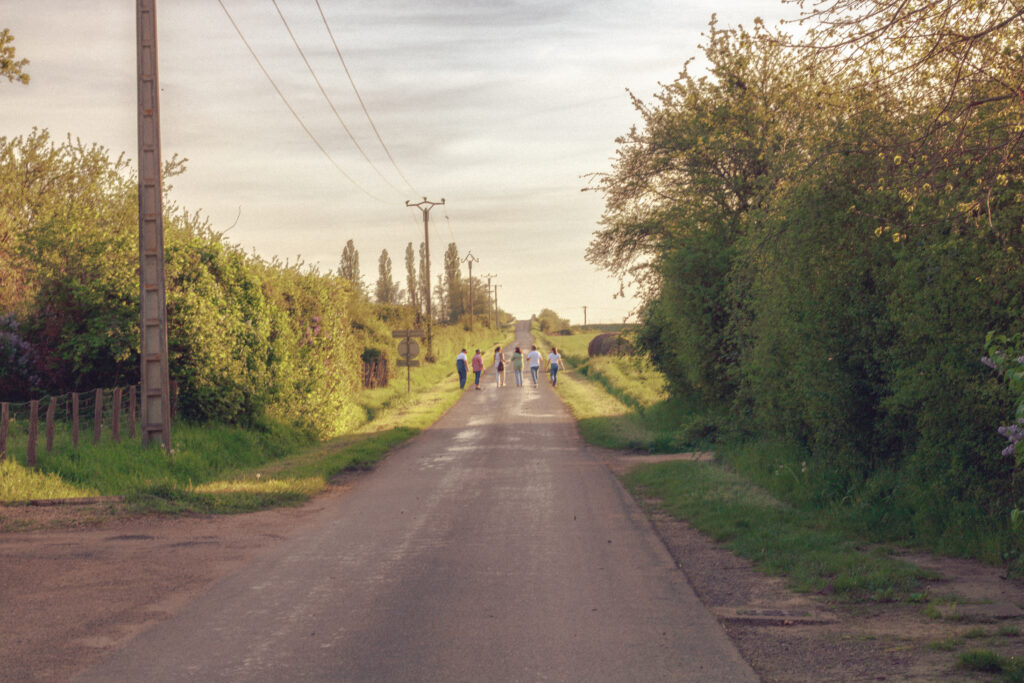 Famille marchant ensemble lors d’une séance photo à Auxerre, lumière naturelle, ambiance cinématique et spontanée.