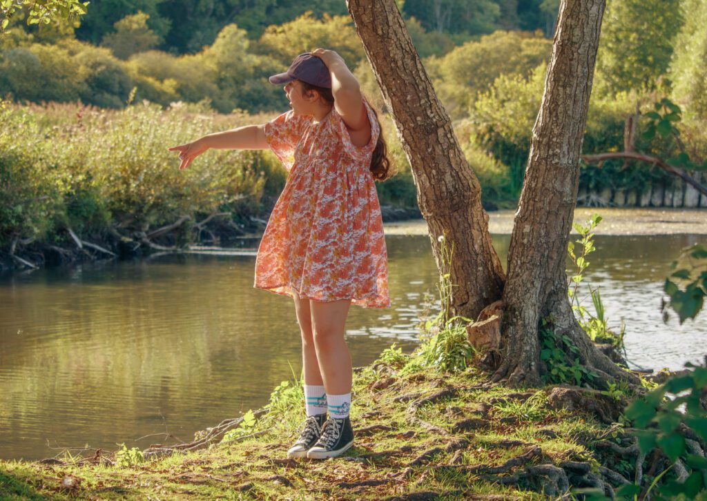 Petite fille regardant l’eau, séance photo de famille à Auxerre, style cinématique et spontané, ambiance naturelle.